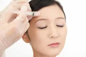 Young woman getting preventative Botox injections to her forehead to stop wrinkles from settling in.