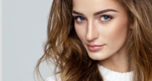 Woman in her 20s maintains flawless skin, taking preventative care with cosmetic treatments.