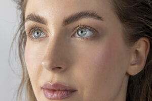 Close-up of a woman’s eyes and brows highlighting the upper eyelid and brow area.
